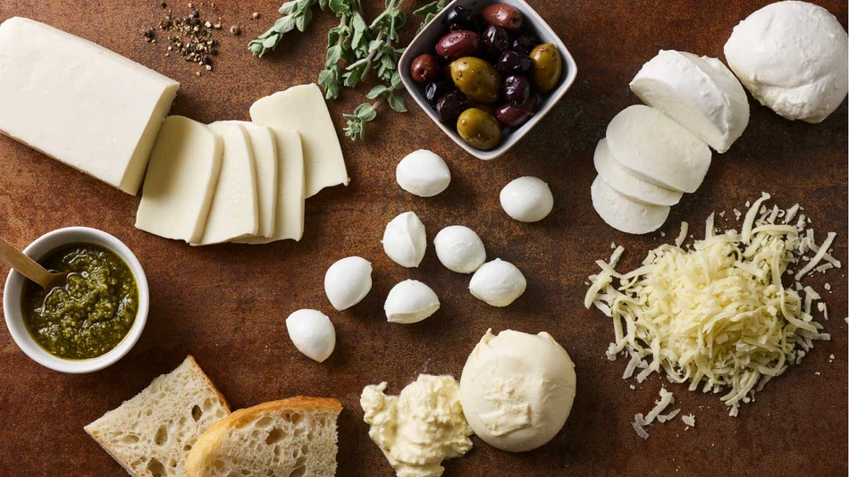 Cheese, olives, bread and herbs on a table spread
