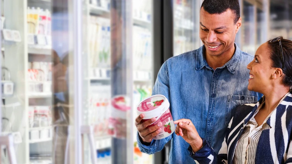 Shelf life labels in dairy - Two people looking at a label in a supermarket
