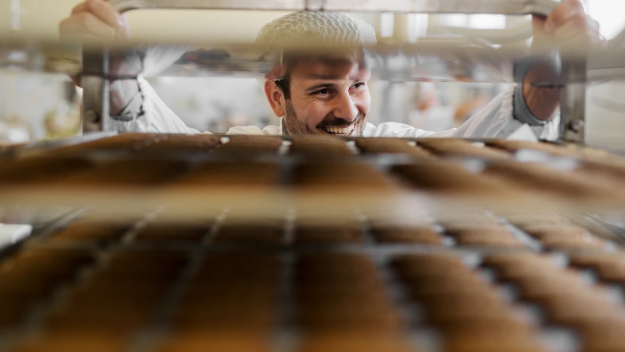 Baker_with_baking_trays_in_industrial_bakery