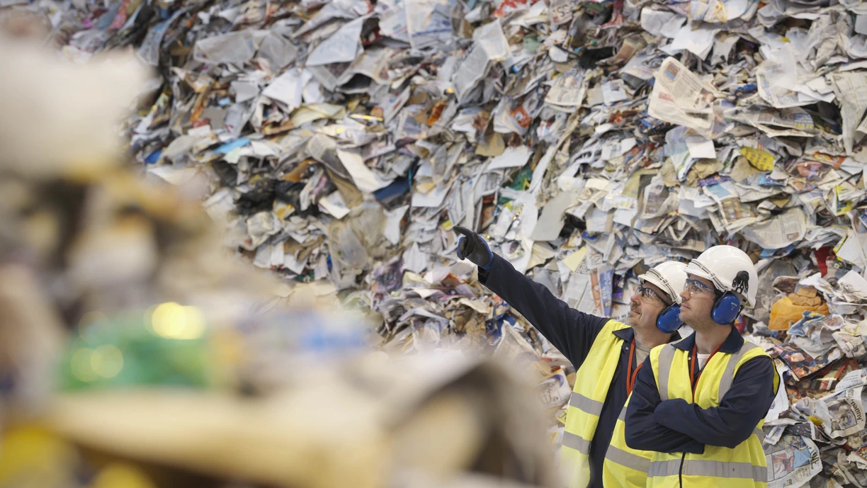 Workers discussing in a paper recycle station