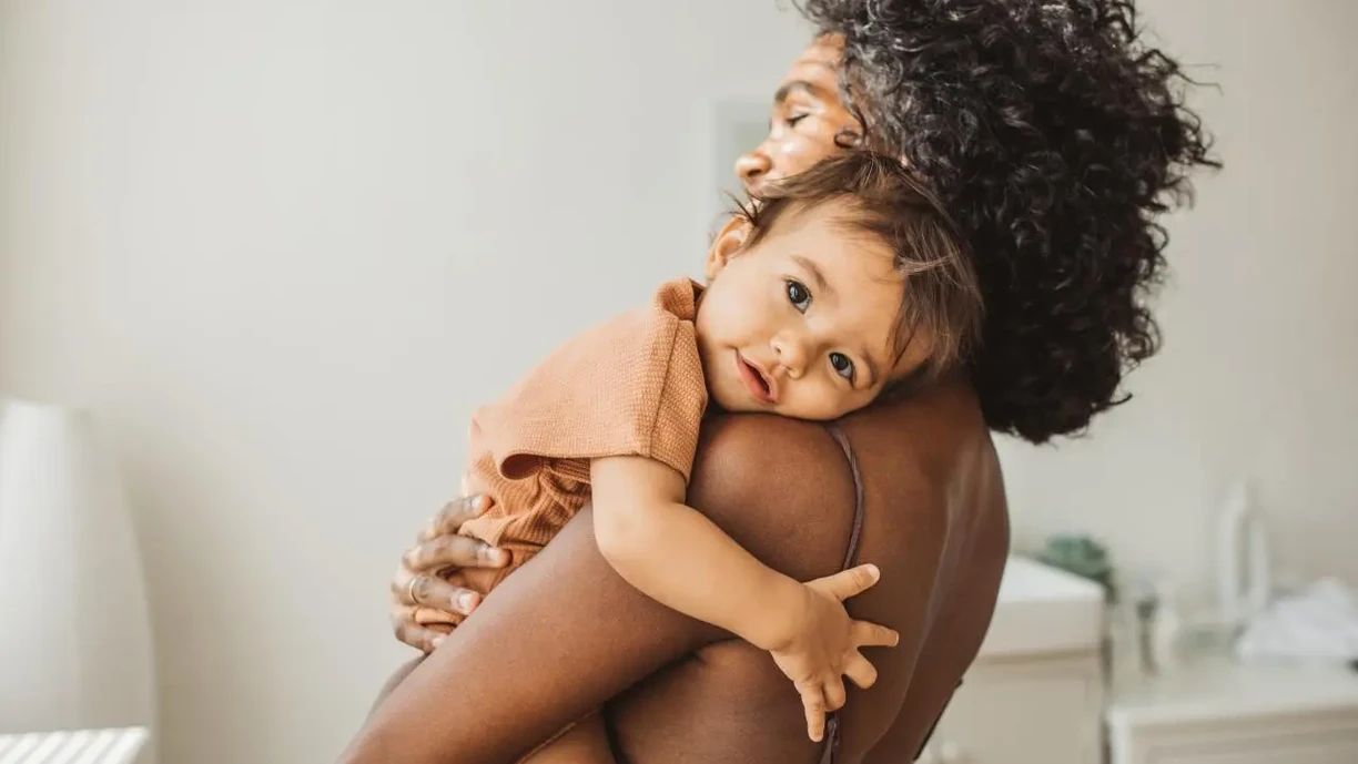 baby hugging mother