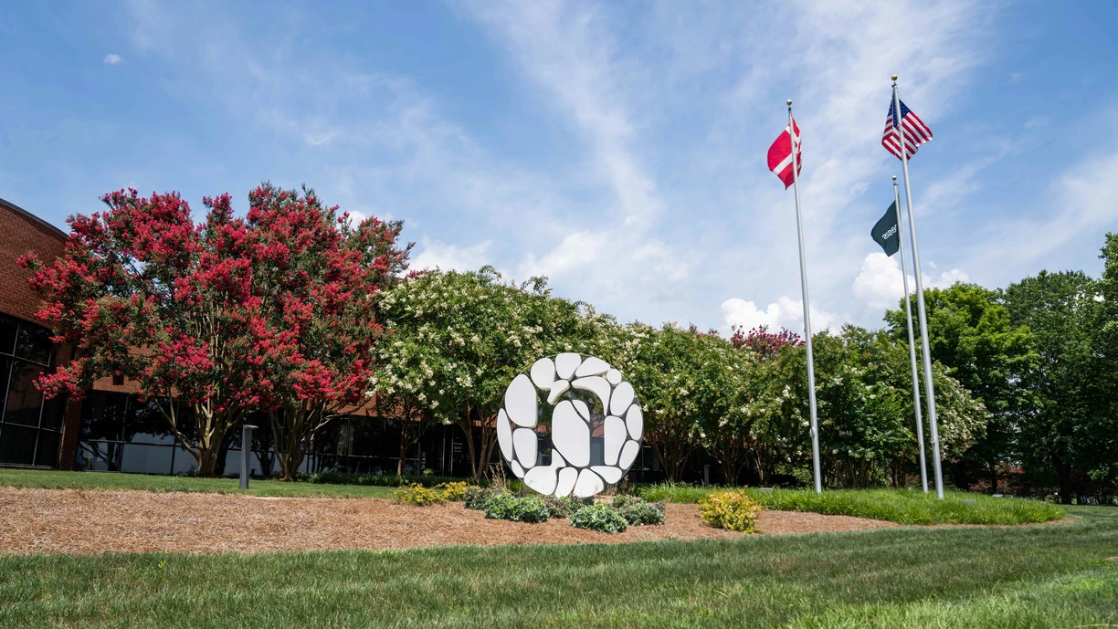 A white NVS monogram statue and flags sit outside NA headquarters in Franklinton, NC