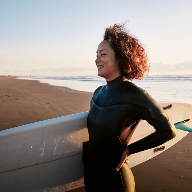 healthy person holding surfboard at the beach