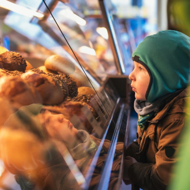 Kid looking at bread in an in-store bakery