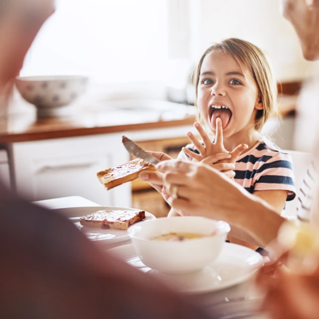 Little_girl_enjoying_tasty_bread_with_family