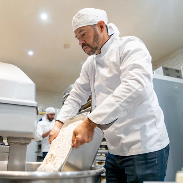 Man pouring flour in mixer 