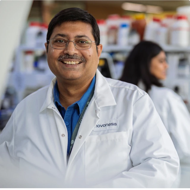 Man in lab coat smiling to camera