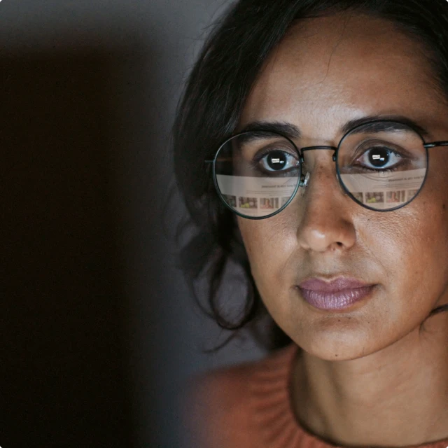 Woman with round glasses looking at computer