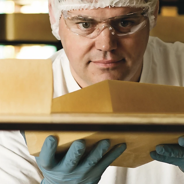 Cheesemaker holding cheese