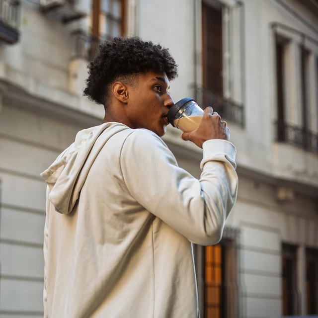 Man drinking plant-based latte outside