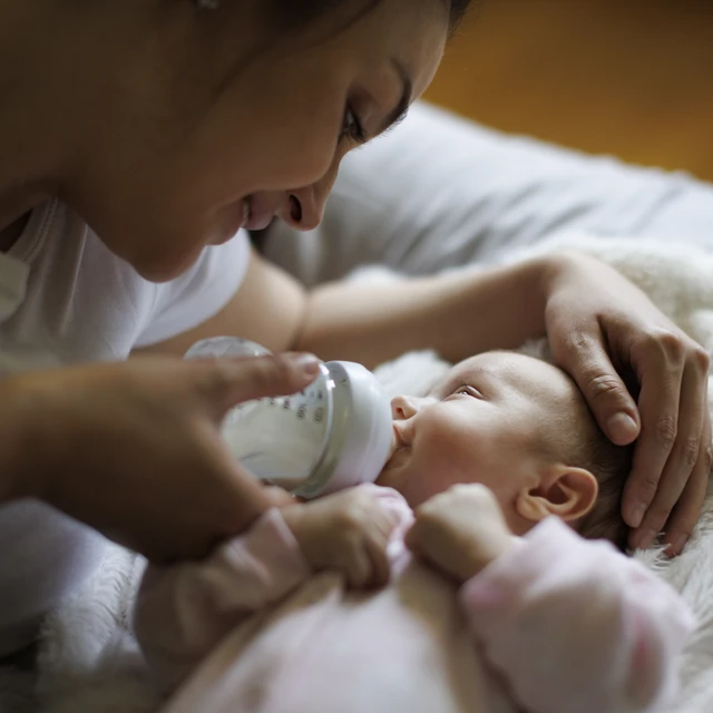A mother feeding her baby using milk bottle