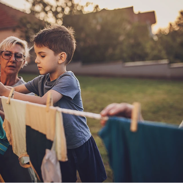 Family hanging laundry to dry in the garden in the summertime