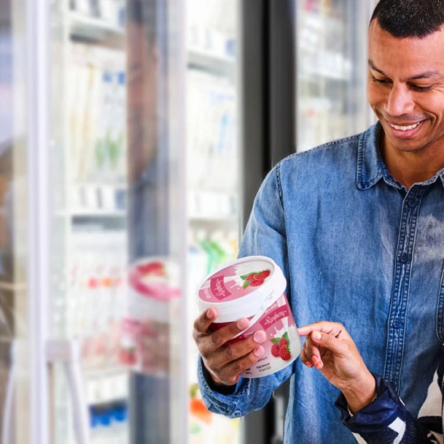 Shelf life labels in dairy - Two people looking at a label in a supermarket