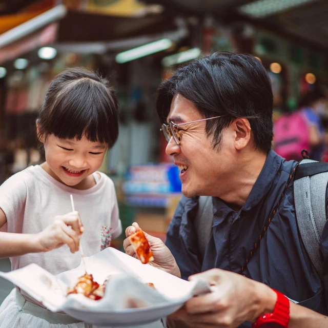 father and daughter eating streetfood