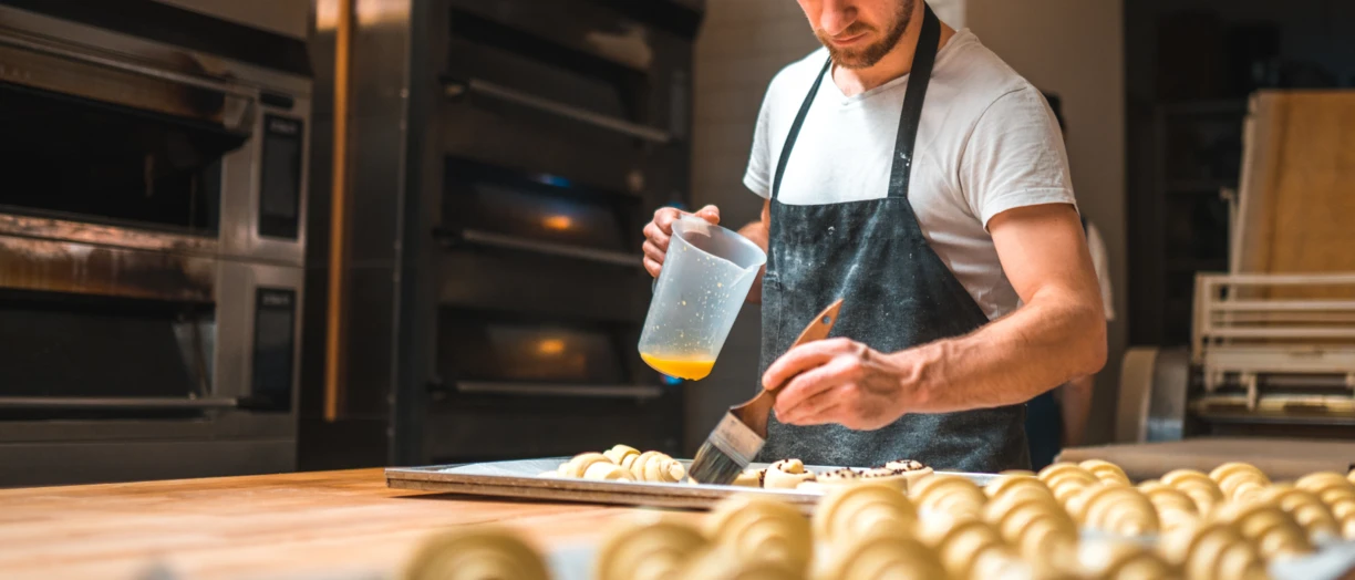 Man buttering croissants 