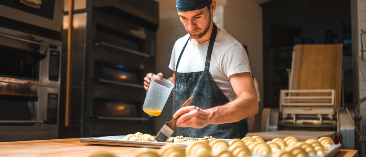 Man buttering croissants
