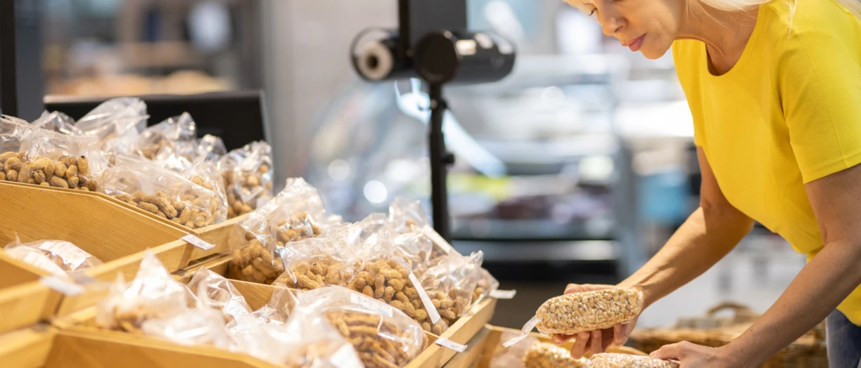 Woman in the grocery store picking a packaged bread