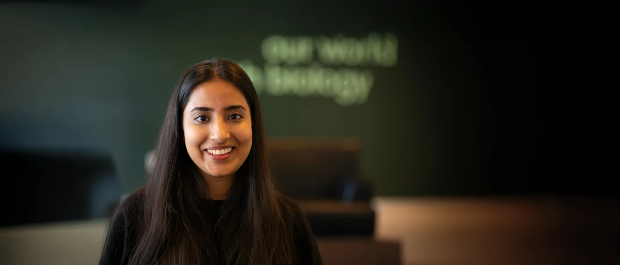 Girl smiling to camera with Novonesis background