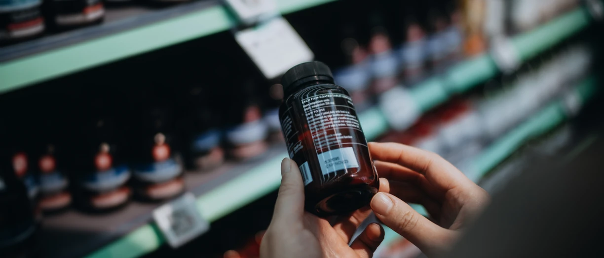 hand holding a bottle of supplements