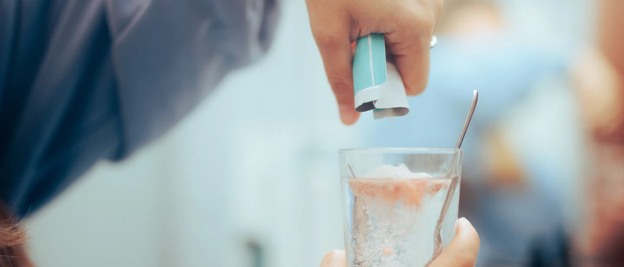 Hand pouring powder in water