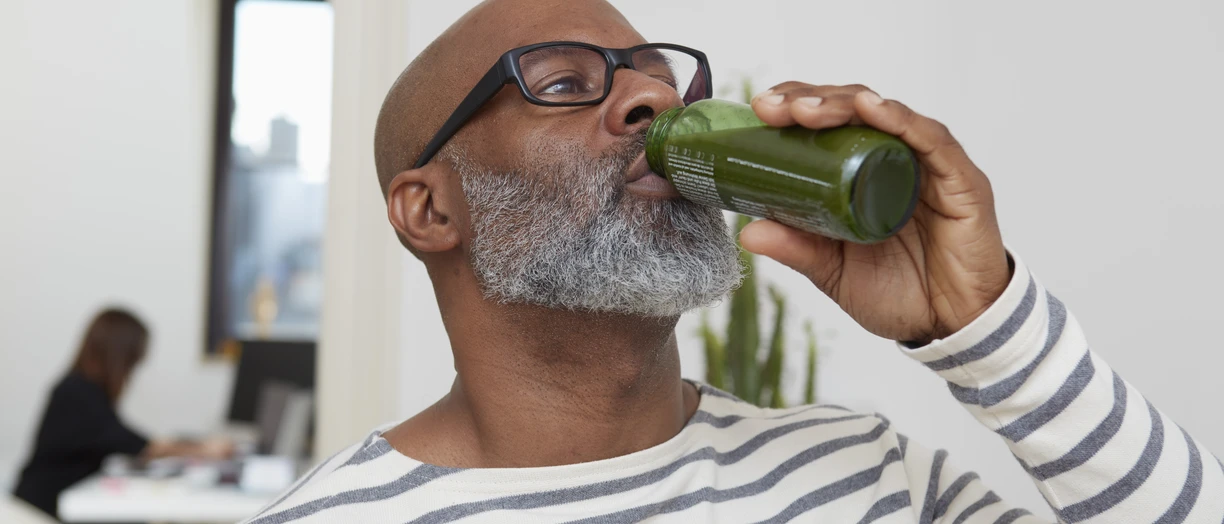 Man drinking green juice