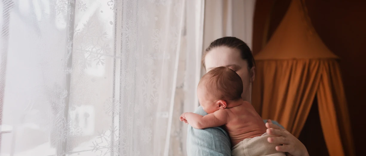 Mature mother comforting her newborn while crying