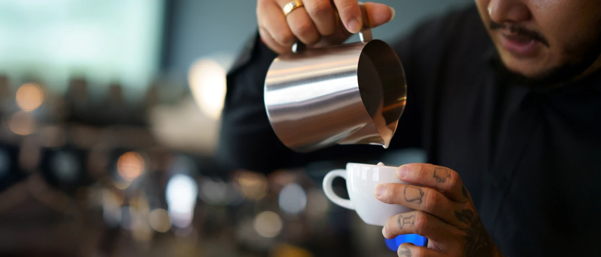 barista pouring hot milk