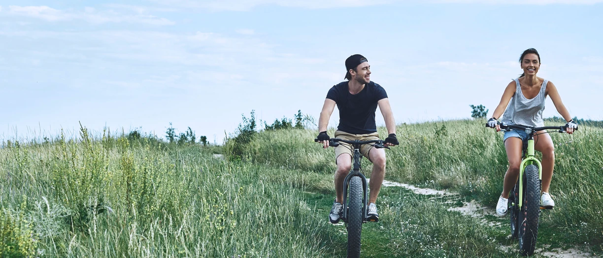man and woman cycling in countryside