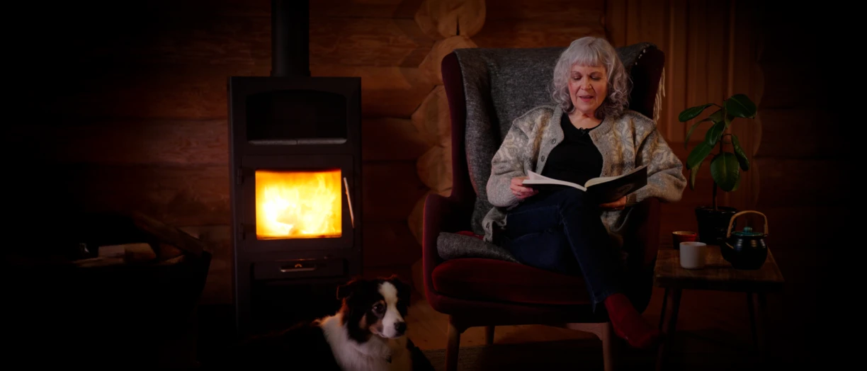 Janet reading the biosolutions bulletin by the fireplace