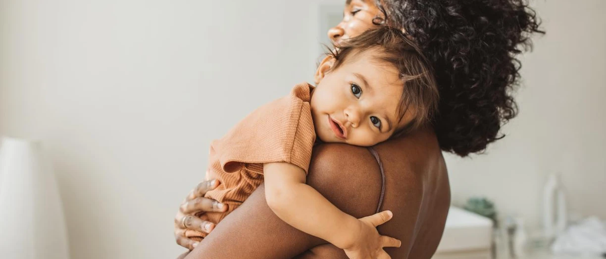 baby hugging mother