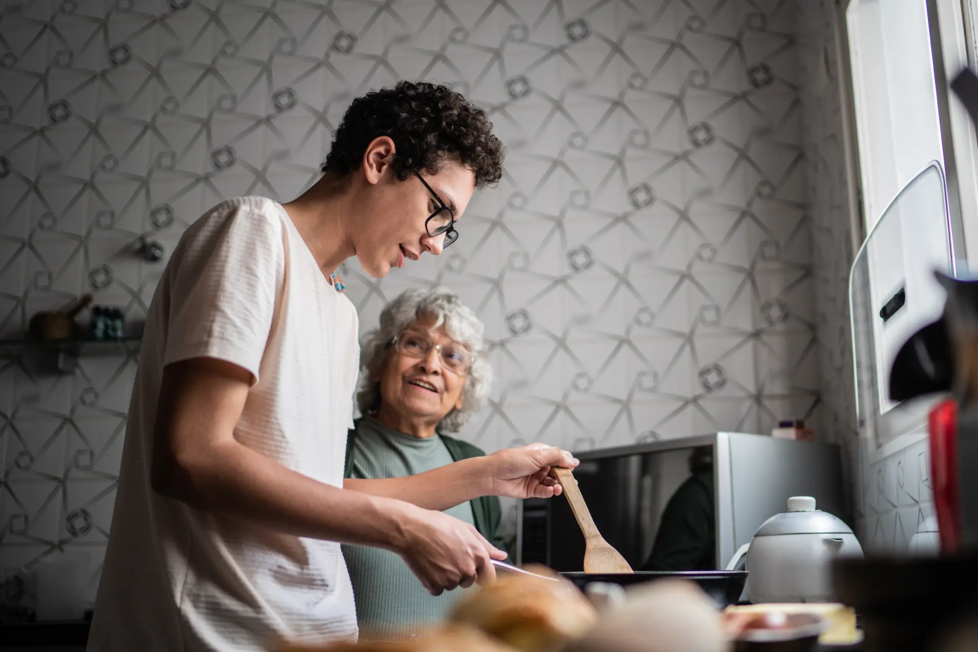 Man partnering up with his grandma in the kitchen
