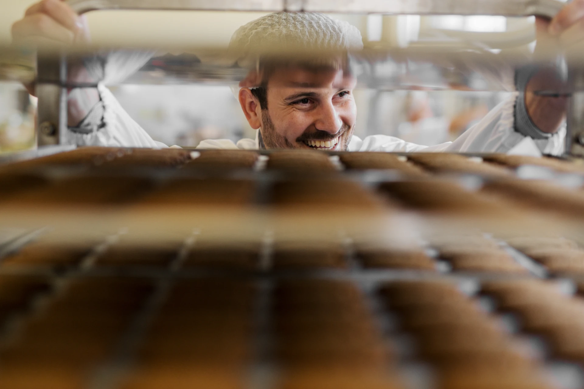 Baker_with_baking_trays_in_industrial_bakery