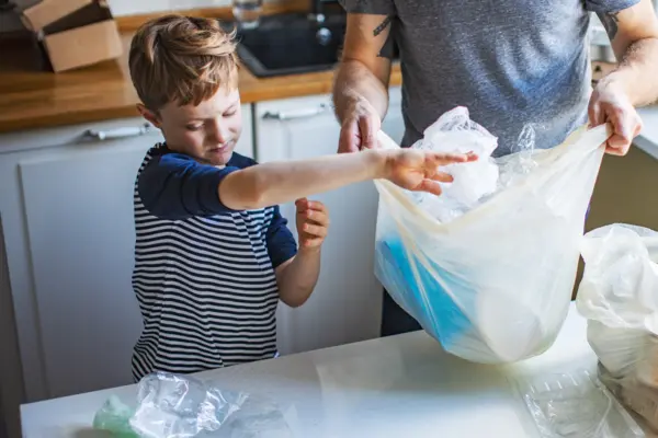Family standing in the kitchen sorting plastic waste