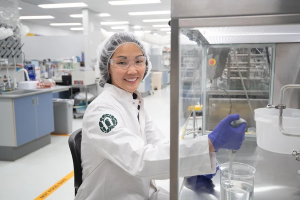 Lab girl smiling to camera in Novonesis coat