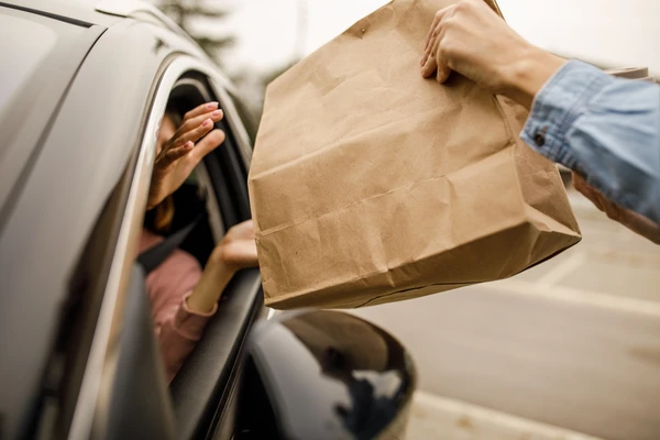customer receiving takeaway food in a paper bag