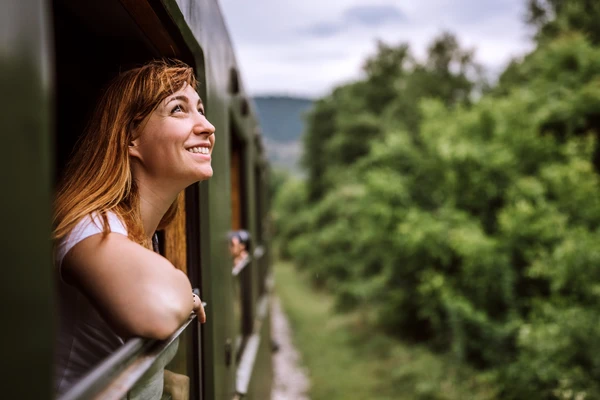 Smiling woman looking out of a window in a train