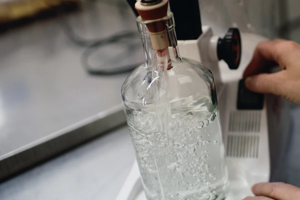 Woman fitting stopper in bottle of gin