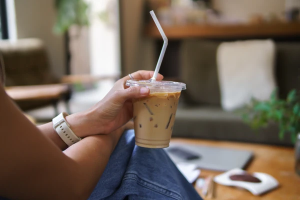 Woman holding take away cup of coffee