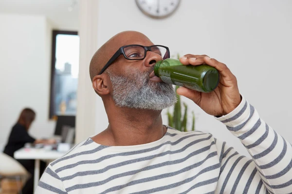 A man drinking a healthy green juice