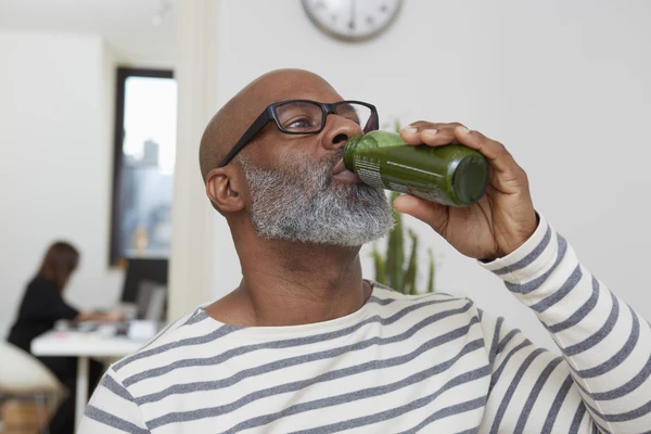 Man drinking cold pressed green juice