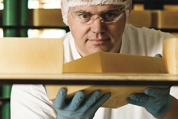 Cheesemaker holding cheese