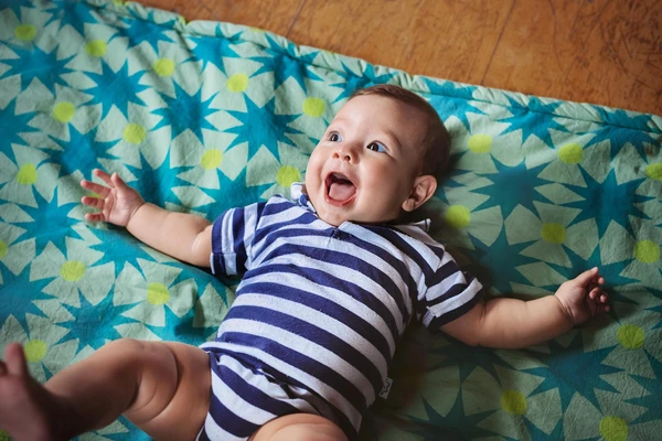 baby happy on blanket