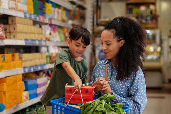 Mother and son shopping for biscuits crackers in the supermarket 