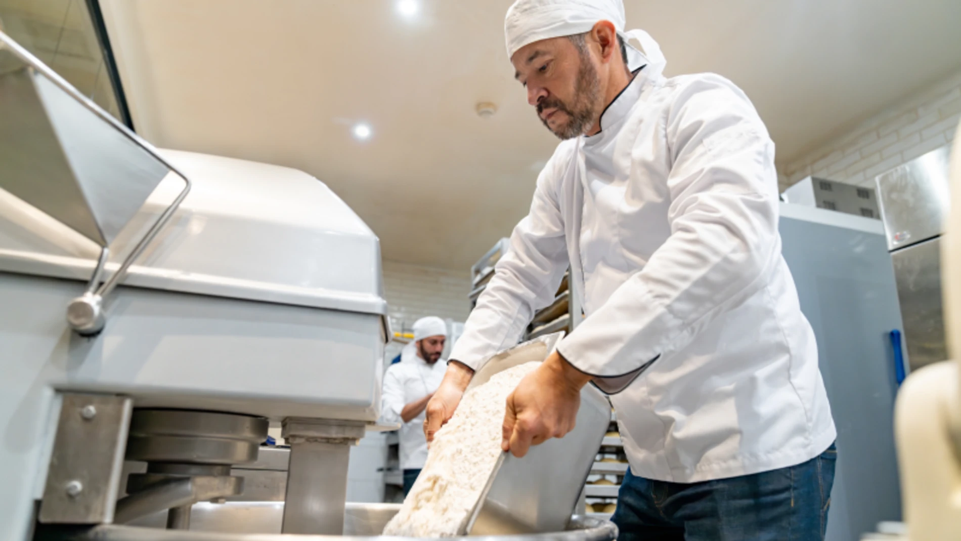 Man pouring flour in mixer