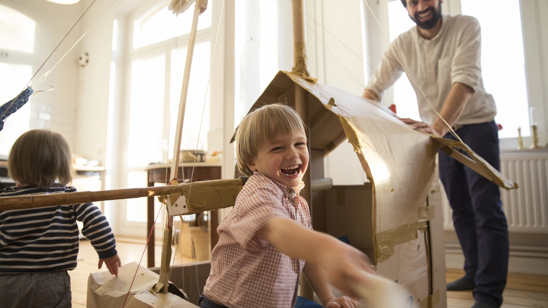 father and son playing with cardboard
