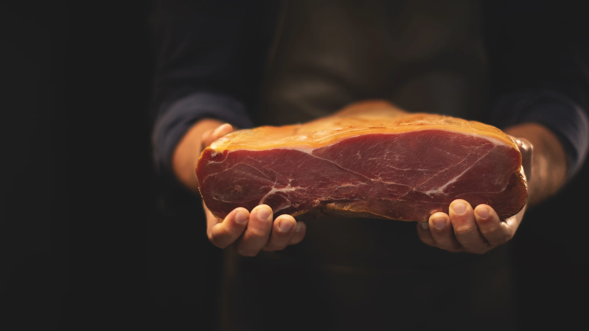 Man holding cured ham