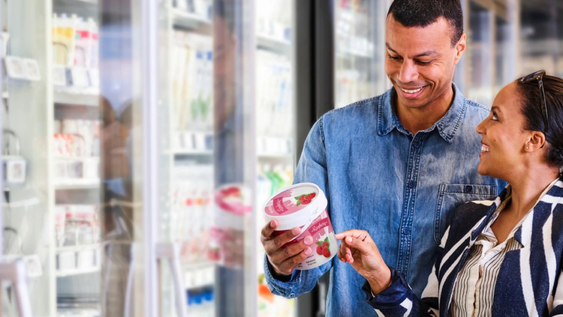 Shelf life labels in dairy - Two people looking at a label in a supermarket