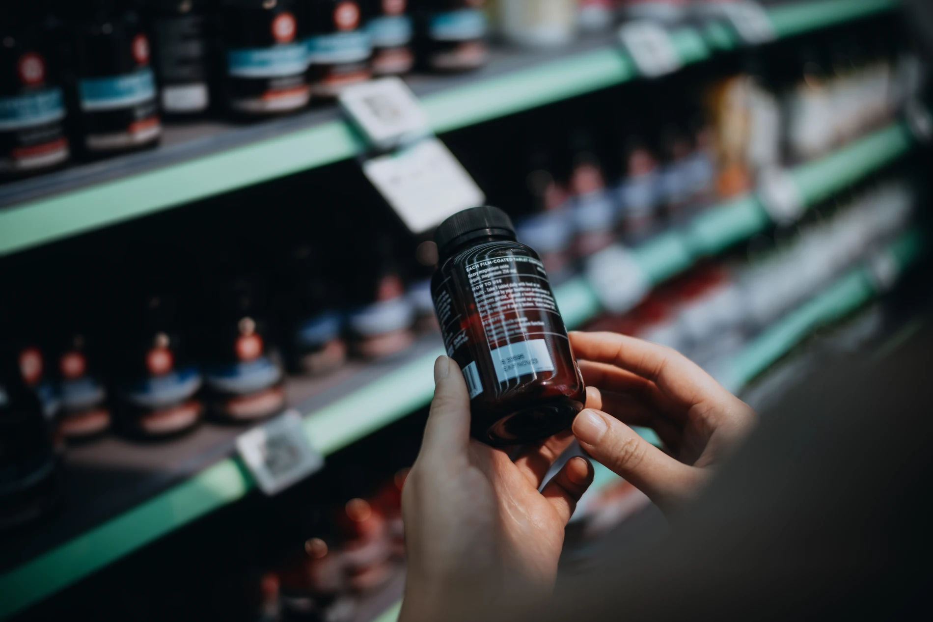 hand holding a bottle of supplements