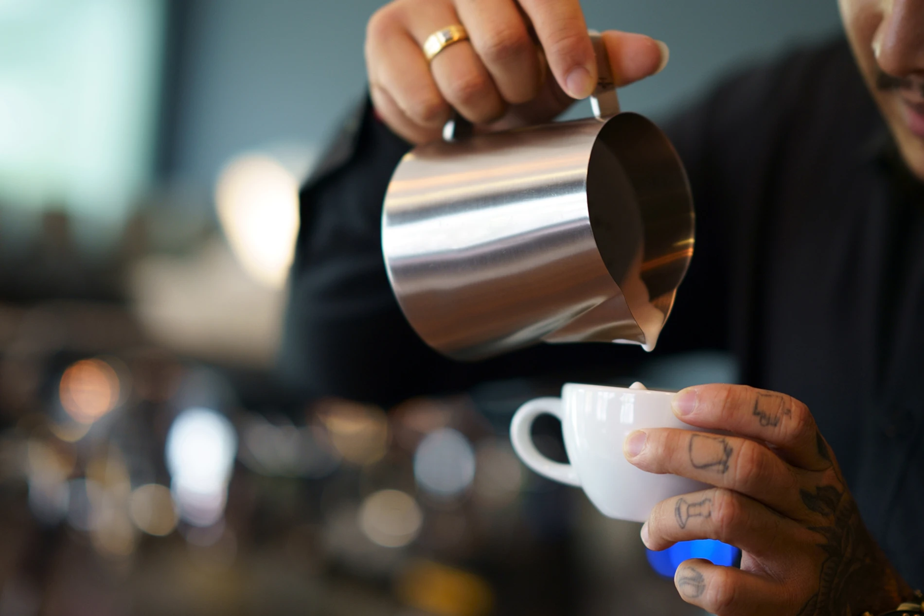 barista pouring hot milk
