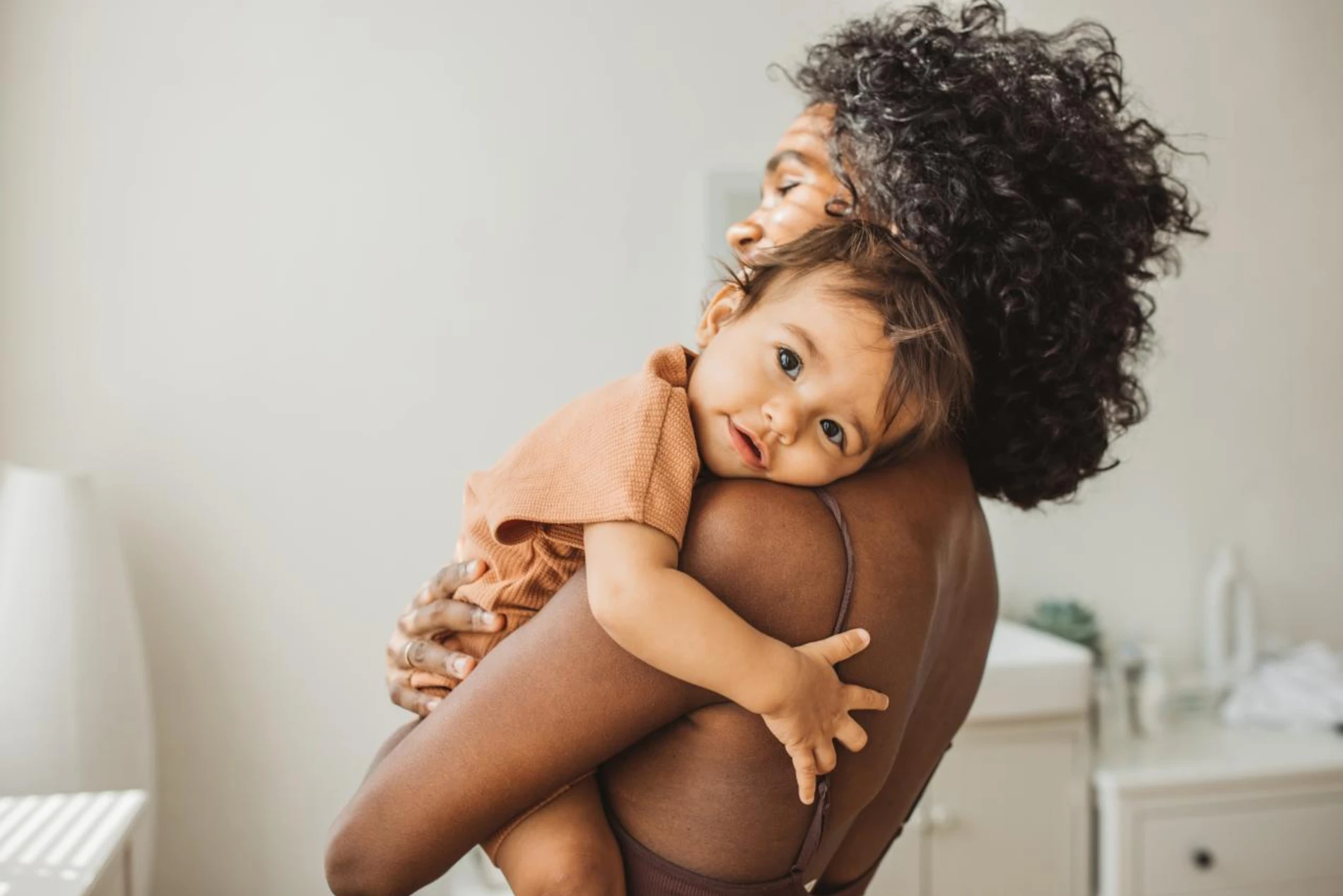 baby hugging mother